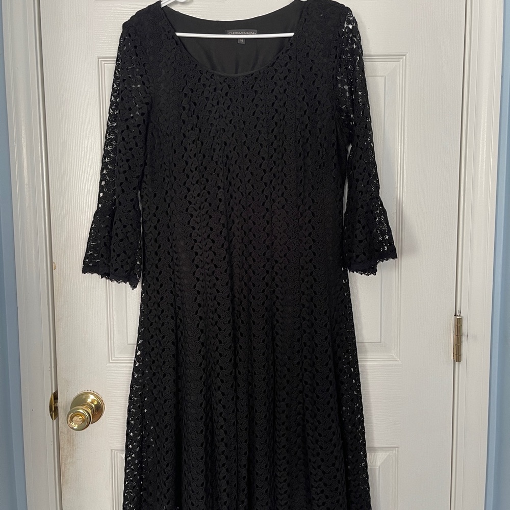 Black dress lined and covered in black eyelets with 3/4 bell sleeves.
